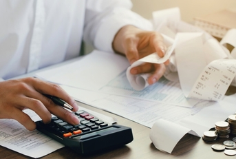 man calculating expenses using calculator