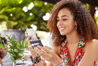 Woman holding a credit card and looking at phone
