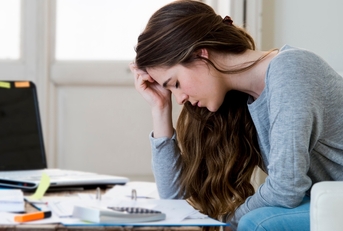 Woman leaning over table looking at bills