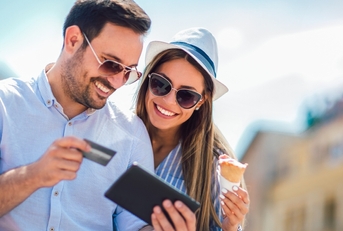 Smiling couple using a credit card on a tablet