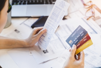 woman looking at many credit cards