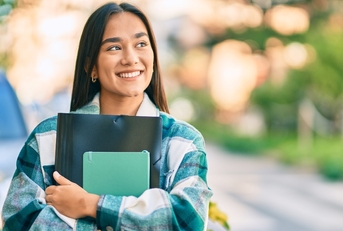 Smiling college student holding notebooks