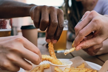 multi ethnic friends eating french fries
