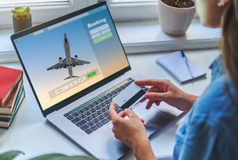 A woman is booking a flight with a credit card