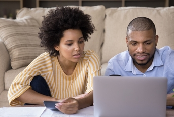 african american family couple calculating expenses