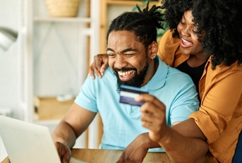 A couple using a cash back credit card online