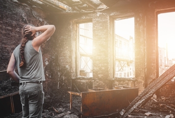 Man standing inside burnt house