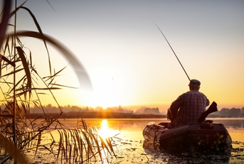 man fishing at sunset in lake