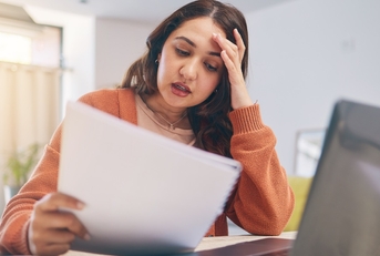 stressed woman reviewing bills at home