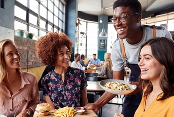 african american waiter serving at restaurant