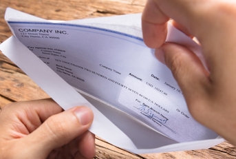 businessman opening envelope with paycheck