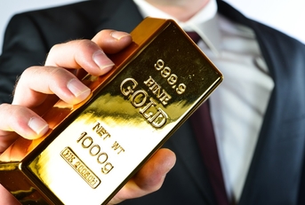 businessman holding 100g fine gold bar