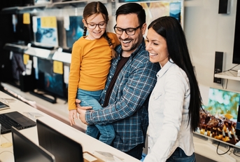 Happy family buying laptop in store