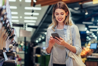 woman using smartphone at grocery store