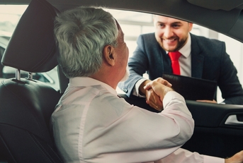 senior man buying car from dealer