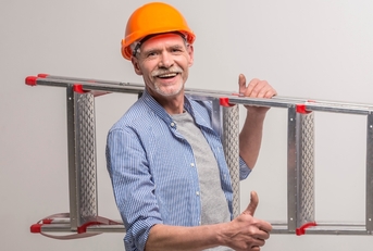 senior builder carrying staircase on site