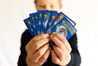 boy holds pokemon trading cards