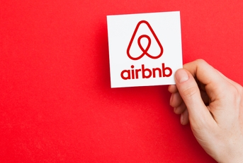 hand holding airbnb logo