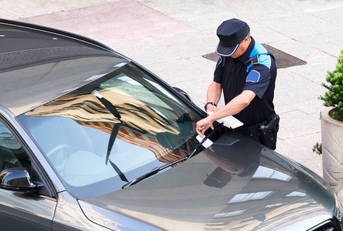police writing parking ticket