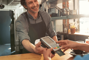 A customer inserts their credit card into a credit card reader.