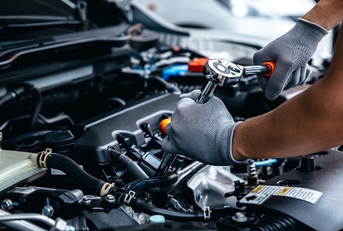 Mechanic repairing engine at garage workshop