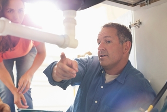 male plumber talking to house owner