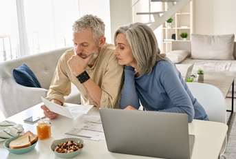 worried senior couple checking documents