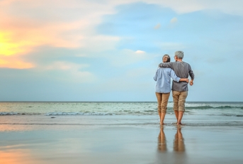 senior couple walking on the beach