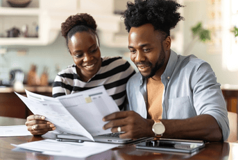 A couple sorts through paperwork. 