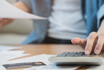 stressed woman reviewing debt using calculator