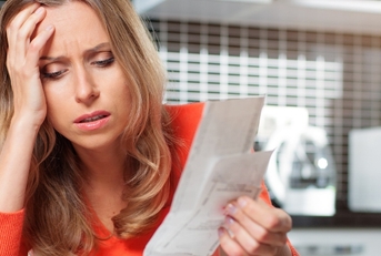Stressed woman looking at bills