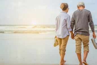 senior couple walking on beach