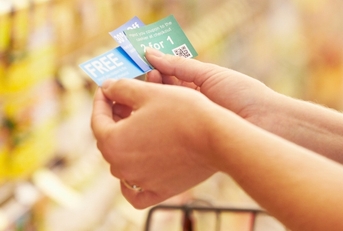 woman in supermarket with coupons
