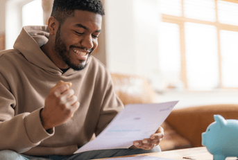 A man expresses excitement as he reads a banking letter. 