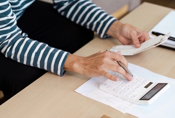 senior woman calculating budget at home