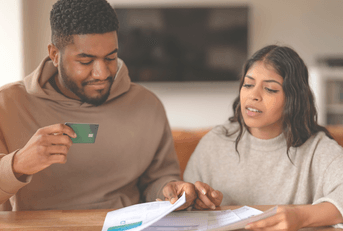 A couple discusses credit card bills together.