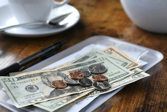 bill tab at cafe with cash money