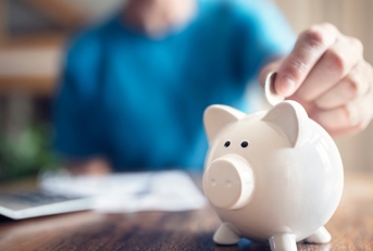 woman putting money in piggy bank