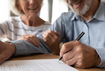 happy senior couple sogning iinsurance policy