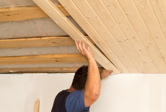 worker working on a wooden ceiling