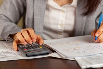 business woman calculating taxes at work