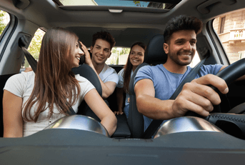 A group of friends drive in a car together.