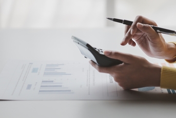Businessman using calculator to calculate bills