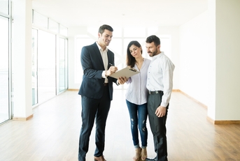 Realtor Explaining Agreement To Couple In Apartment
