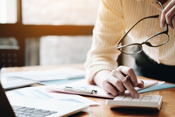 Businesswoman using calculator and laptop
