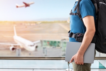man traveling with laptop at airport