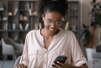 A woman looks at her phone at home. 