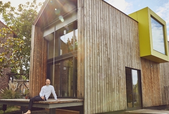 senior man with beer sitting outside house