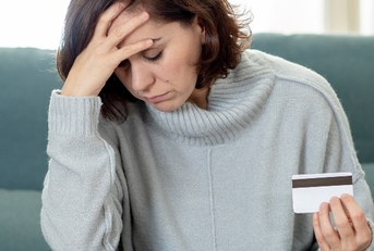 Stressed woman holding credit card