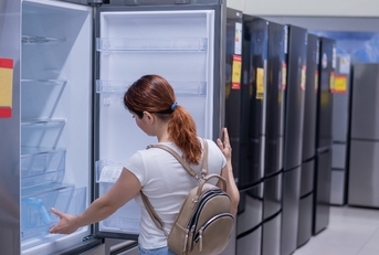 Woman chooses a refrigerator